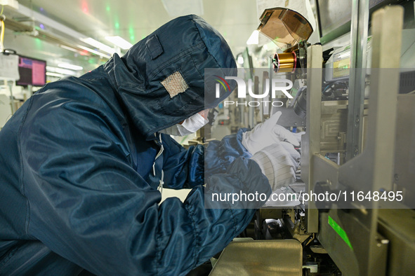 A worker works on an electronic component production line at Jiangsu Baopulai Semiconductor Co LTD in the Siyang Economic Development Zone i...