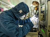 A worker works on an electronic component production line at Jiangsu Baopulai Semiconductor Co LTD in the Siyang Economic Development Zone i...