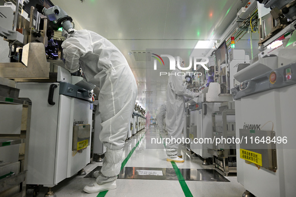 A worker works on an electronic component production line at Jiangsu Baopulai Semiconductor Co LTD in the Siyang Economic Development Zone i...