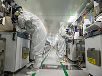 A worker works on an electronic component production line at Jiangsu Baopulai Semiconductor Co LTD in the Siyang Economic Development Zone i...