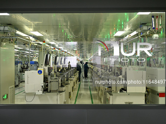 A worker works on an electronic component production line at Jiangsu Baopulai Semiconductor Co LTD in the Siyang Economic Development Zone i...