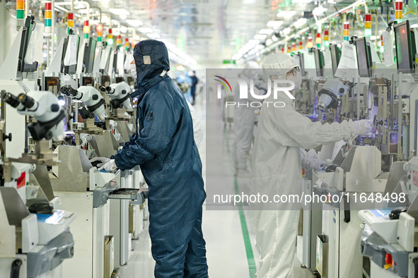 A worker works on an electronic component production line at Jiangsu Baopulai Semiconductor Co LTD in the Siyang Economic Development Zone i...