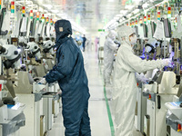 A worker works on an electronic component production line at Jiangsu Baopulai Semiconductor Co LTD in the Siyang Economic Development Zone i...