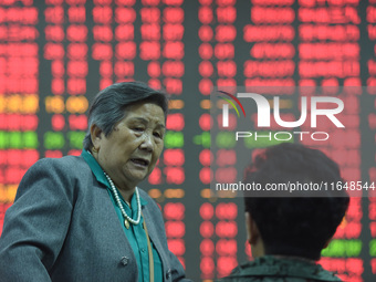 A customer pays attention to the stock market at a stock exchange in Hangzhou, China, on October 8, 2024. (