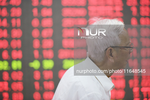 A customer pays attention to the stock market at a stock exchange in Hangzhou, China, on October 8, 2024. 