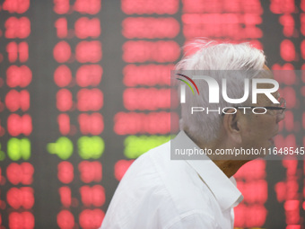 A customer pays attention to the stock market at a stock exchange in Hangzhou, China, on October 8, 2024. (