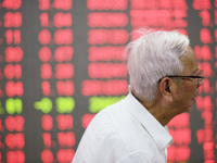 A customer pays attention to the stock market at a stock exchange in Hangzhou, China, on October 8, 2024. (