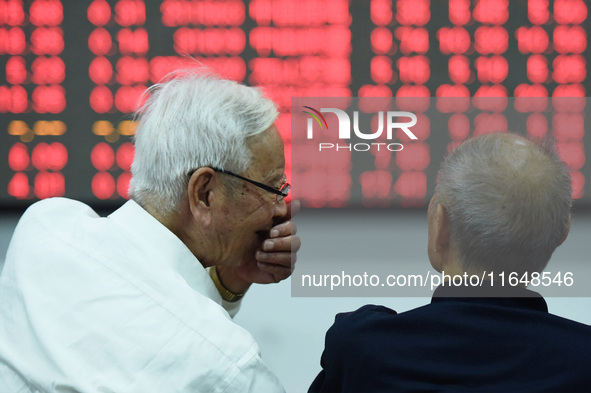 A customer pays attention to the stock market at a stock exchange in Hangzhou, China, on October 8, 2024. 