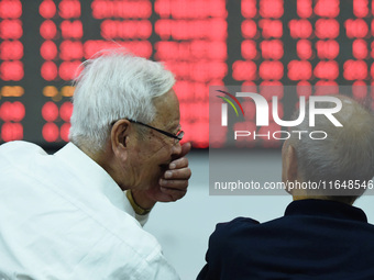 A customer pays attention to the stock market at a stock exchange in Hangzhou, China, on October 8, 2024. (