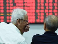 A customer pays attention to the stock market at a stock exchange in Hangzhou, China, on October 8, 2024. (