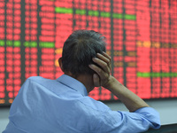 A customer pays attention to the stock market at a stock exchange in Hangzhou, China, on October 8, 2024. (