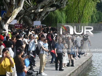 Crowds of people gather at West Lake during the National Day holiday in Hangzhou, China, on October 2, 2024. On October 8, 2024, according t...