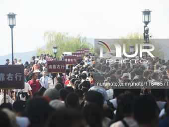 Crowds of people gather at West Lake during the National Day holiday in Hangzhou, China, on October 2, 2024. On October 8, 2024, according t...