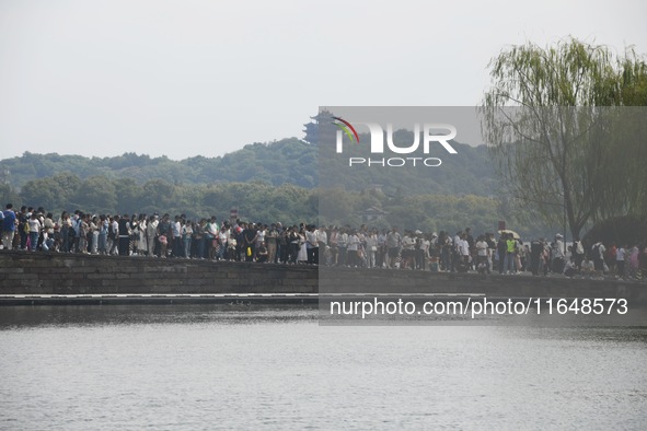 Crowds of people gather at West Lake during the National Day holiday in Hangzhou, China, on October 2, 2024. On October 8, 2024, according t...