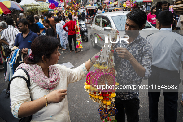 A woman buys decorative items at a street market ahead of the Durga Puja festival in Guwahati, India, on October 7, 2024. Shopping ahead of...