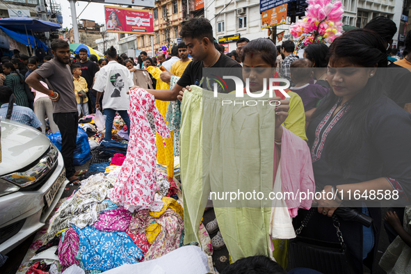 People buy clothes at a street market ahead of the Durga Puja festival in Guwahati, India, on October 7, 2024. Shopping ahead of Durga Puja...