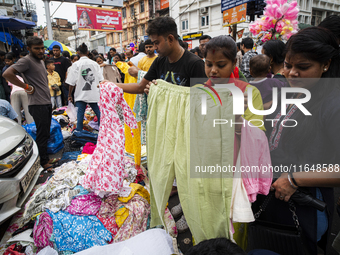 People buy clothes at a street market ahead of the Durga Puja festival in Guwahati, India, on October 7, 2024. Shopping ahead of Durga Puja...