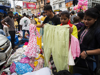 People buy clothes at a street market ahead of the Durga Puja festival in Guwahati, India, on October 7, 2024. Shopping ahead of Durga Puja...