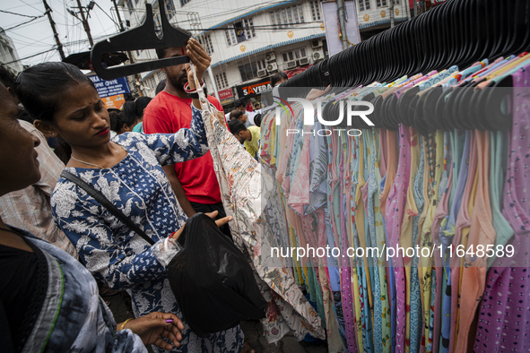 People buy clothes at a street market ahead of the Durga Puja festival in Guwahati, India, on October 7, 2024. Shopping ahead of Durga Puja...