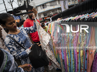 People buy clothes at a street market ahead of the Durga Puja festival in Guwahati, India, on October 7, 2024. Shopping ahead of Durga Puja...