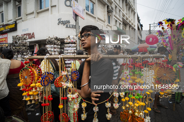 A boy sells decorative items at a street market ahead of the Durga Puja festival in Guwahati, India, on October 7, 2024. Shopping ahead of D...