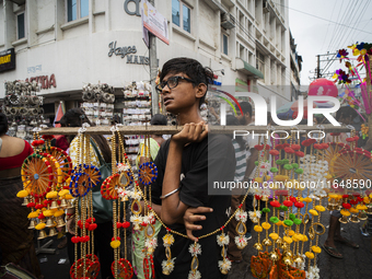 A boy sells decorative items at a street market ahead of the Durga Puja festival in Guwahati, India, on October 7, 2024. Shopping ahead of D...