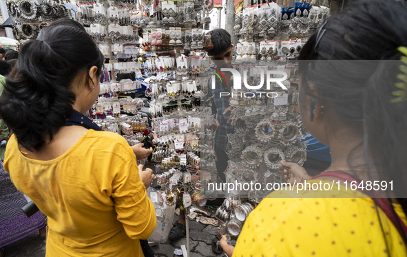 A woman buys jewelry at a street market ahead of the Durga Puja festival in Guwahati, India, on October 7, 2024. Shopping ahead of Durga Puj...