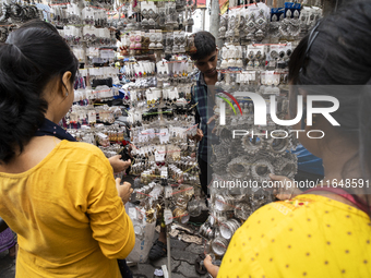 A woman buys jewelry at a street market ahead of the Durga Puja festival in Guwahati, India, on October 7, 2024. Shopping ahead of Durga Puj...