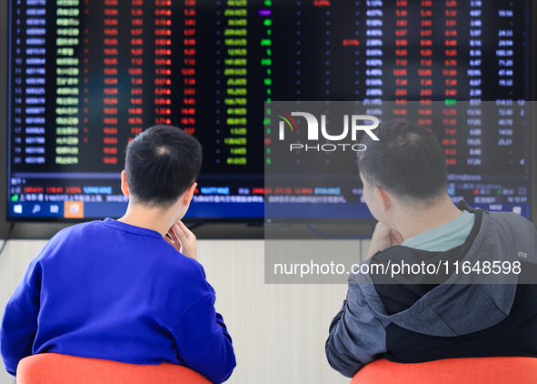 Investors pay attention to the stock market at a securities sales department in Nanjing, China, on October 8, 2024. 