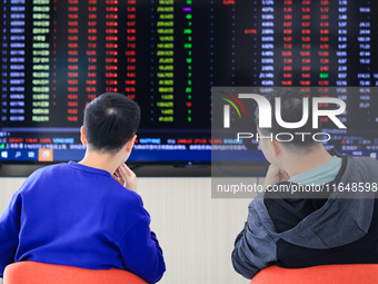 Investors pay attention to the stock market at a securities sales department in Nanjing, China, on October 8, 2024. (