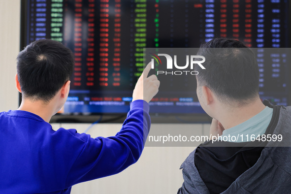 Investors pay attention to the stock market at a securities sales department in Nanjing, China, on October 8, 2024. 