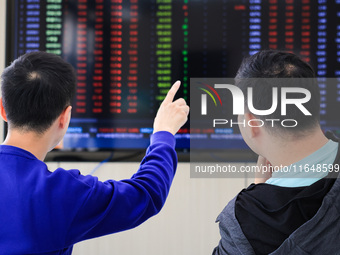 Investors pay attention to the stock market at a securities sales department in Nanjing, China, on October 8, 2024. (