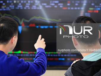 Investors pay attention to the stock market at a securities sales department in Nanjing, China, on October 8, 2024. (