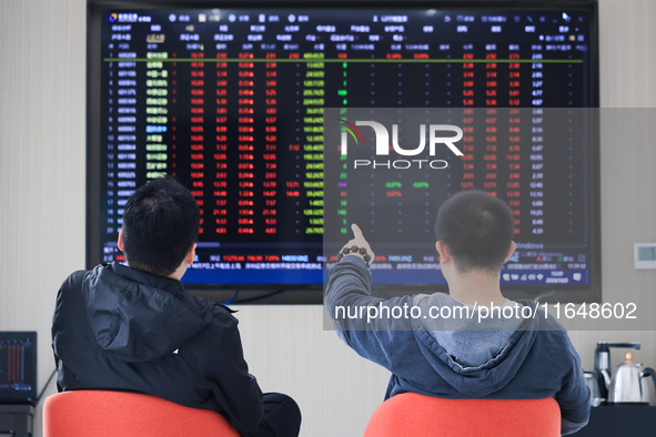 Investors pay attention to the stock market at a securities sales department in Nanjing, China, on October 8, 2024. 