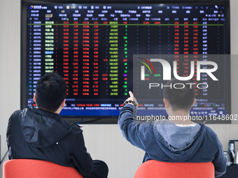 Investors pay attention to the stock market at a securities sales department in Nanjing, China, on October 8, 2024. (