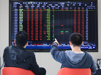 Investors pay attention to the stock market at a securities sales department in Nanjing, China, on October 8, 2024. (