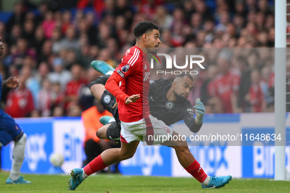 Robert Sanchez, Chelsea goalkeeper, dives as Morgan Gibbs-White of Nottingham Forest watches the ball after Chris Wood of Nottingham Forest...