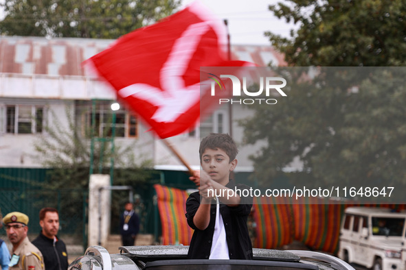 A boy holds a flag of the National Conference party in Baramulla, Jammu and Kashmir, India, on October 8, 2024. 