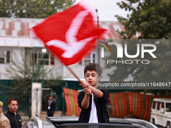 A boy holds a flag of the National Conference party in Baramulla, Jammu and Kashmir, India, on October 8, 2024. (