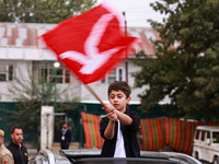 A boy holds a flag of the National Conference party in Baramulla, Jammu and Kashmir, India, on October 8, 2024. (