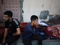 Palestinians mourn their relatives who are killed in overnight Israeli airstrikes on the Al-Bureij refugee camp in central Gaza at the Al-Aq...