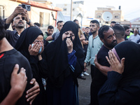 Palestinians mourn their relatives who are killed in overnight Israeli airstrikes on the Al-Bureij refugee camp in central Gaza at the Al-Aq...