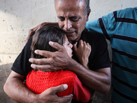 Palestinians mourn their relatives who are killed in overnight Israeli airstrikes on the Al-Bureij refugee camp in central Gaza at the Al-Aq...