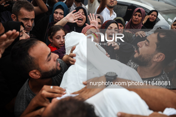 Palestinians mourn their relatives who are killed in overnight Israeli airstrikes on the Al-Bureij refugee camp in central Gaza at the Al-Aq...