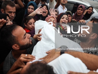 Palestinians mourn their relatives who are killed in overnight Israeli airstrikes on the Al-Bureij refugee camp in central Gaza at the Al-Aq...