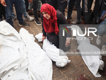 Palestinians mourn their relatives who are killed in overnight Israeli airstrikes on the Al-Bureij refugee camp in central Gaza at the Al-Aq...