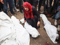 Palestinians mourn their relatives who are killed in overnight Israeli airstrikes on the Al-Bureij refugee camp in central Gaza at the Al-Aq...