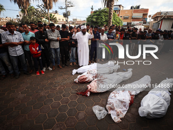 Palestinians mourn their relatives who are killed in overnight Israeli airstrikes on the Al-Bureij refugee camp in central Gaza at the Al-Aq...