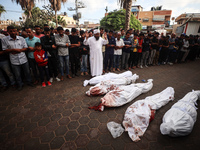 Palestinians mourn their relatives who are killed in overnight Israeli airstrikes on the Al-Bureij refugee camp in central Gaza at the Al-Aq...