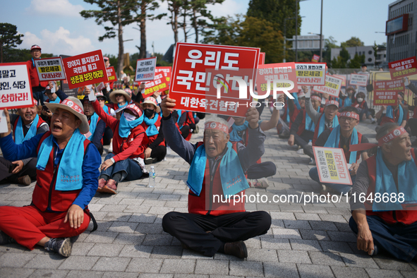 Attendees of a protest organized by around 200 members of the Korea Dog Meat Association and the Korea Dog Meat Sellers' Association hold pl...